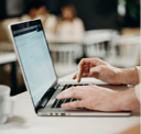 Person typing at a laptop computer.